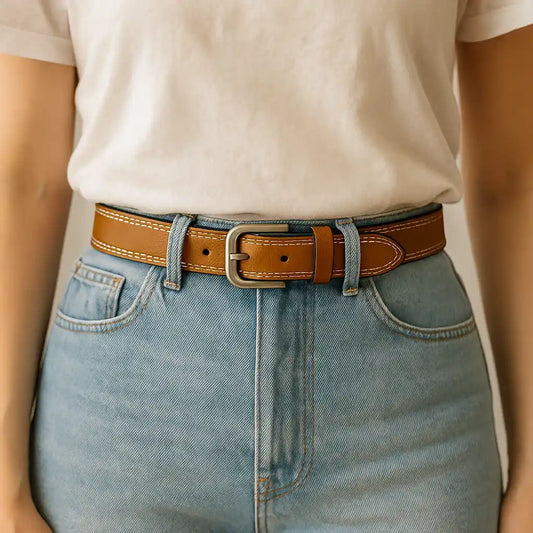 Mujer con vaqueros de tiro alto llevando cinturón de cuero color caramelo con hebilla metálica