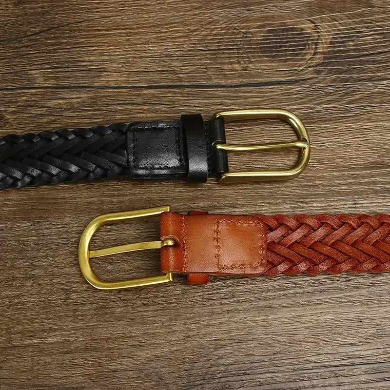 vista superior de dos cinturones trenzados en cuero negro y marron con hebilla dorada