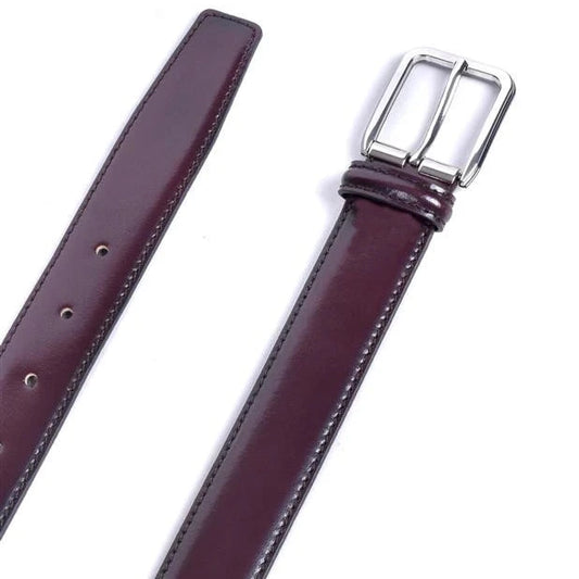 detalle del cinturon de piel burdeos con hebilla plateada y punta en pico acabado liso brillante