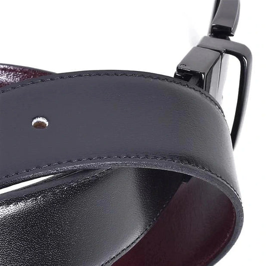 detalle del cinturon reversible en piel con lado negro y reverso marron con hebilla niquel negro