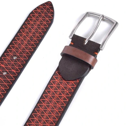 detalle de hebilla niquel viejo y pasador sobre cinturon con rombos rojos