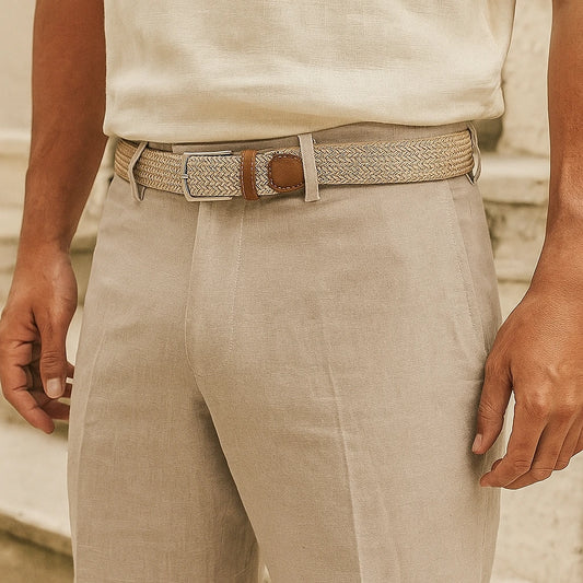 Cinturón trenzado elástico beige con hebilla metálica, combinado con pantalón claro de lino