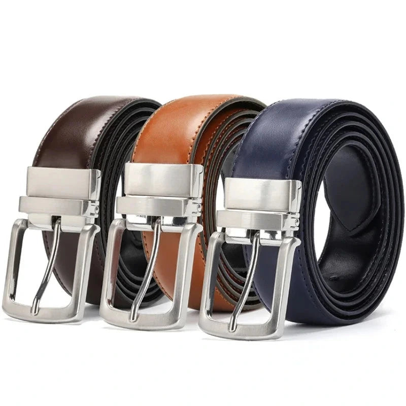 Tres cinturones reversibles enrollados en marron oscuro marron claro y azul con hebillas metalicas