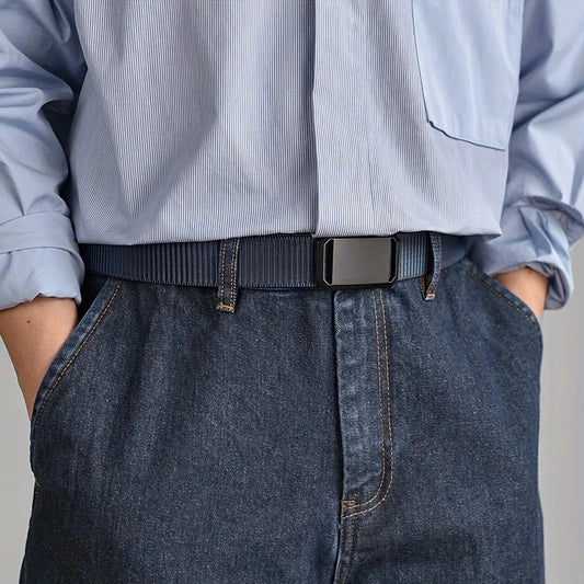 cinturón azul de lona con hebilla negra usado con camisa clara y pantalón vaquero