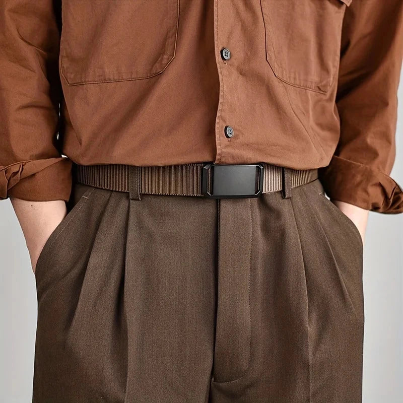 cinturón marrón de lona con hebilla negra usado con camisa marrón y pantalón de vestir